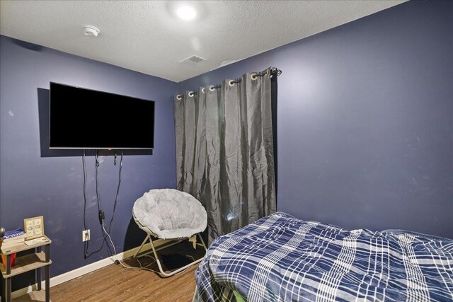 65 N Brown Rd, Bailey, MI 49303 - bedroom featuring wood finished floors, baseboards, and a textured ceiling