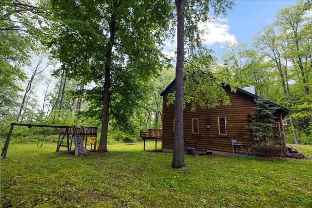 65 N Brown Rd, Bailey, MI 49303 - view of green lawn with a playground and a deck