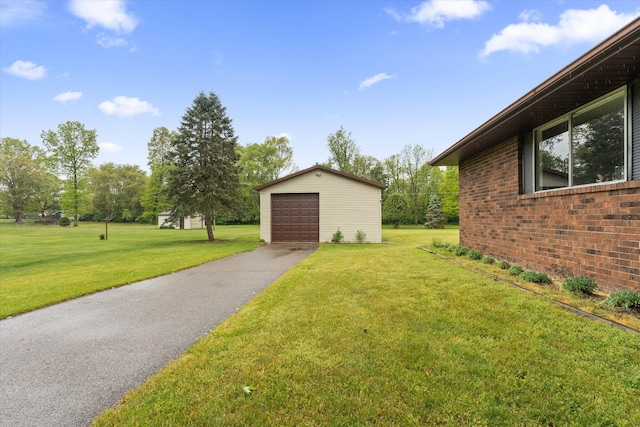 70594 Dennis Dr, Niles, MI 49120 - view of green lawn featuring a detached garage, an outbuilding, and asphalt driveway