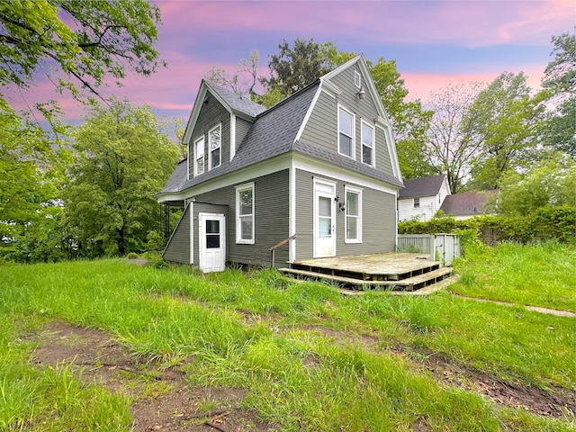 93 Goguac St E, Battle Creek, MI 49015 - rear view of property featuring a deck, a gambrel roof, and a shingled roof