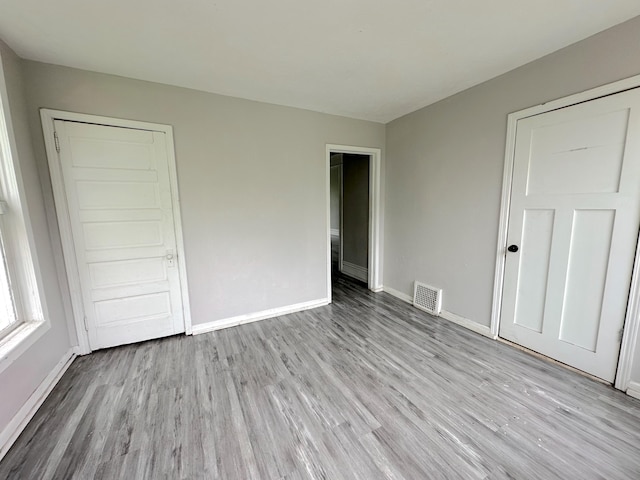 93 Goguac St E, Battle Creek, MI 49015 - unfurnished bedroom featuring wood finished floors and baseboards