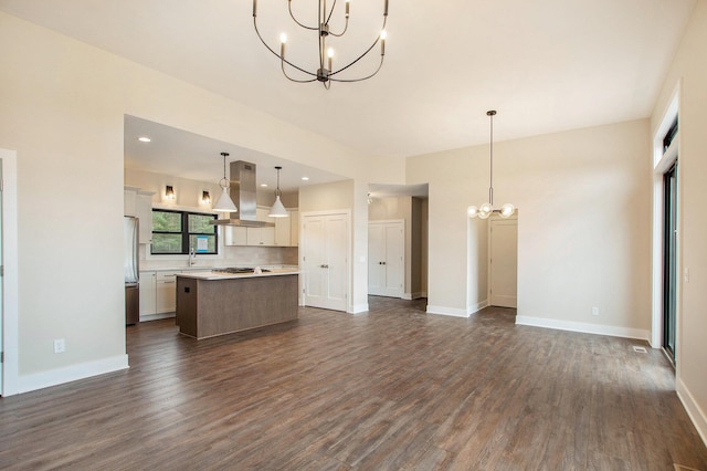 0 Baldwin St, Hudsonville, MI 49426 - unfurnished living room featuring a chandelier, dark wood-type flooring, a sink, and baseboards