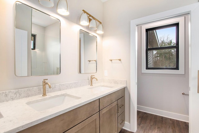 0 Baldwin St, Hudsonville, MI 49426 - bathroom featuring double vanity, wood finished floors, and baseboards