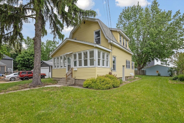 2218 Dalton Ave SW, Wyoming, MI 49519 - colonial inspired home featuring a gambrel roof, entry steps, a front lawn, and a detached garage