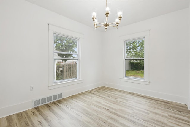 2218 Dalton Ave SW, Wyoming, MI 49519 - spare room featuring a chandelier, wood finished floors, plenty of natural light, and baseboards
