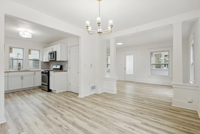 2218 Dalton Ave SW, Wyoming, MI 49519 - kitchen featuring stainless steel appliances, light wood finished floors, open floor plan, and a chandelier