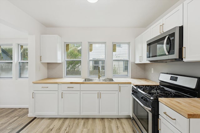 2218 Dalton Ave SW, Wyoming, MI 49519 - kitchen featuring stainless steel appliances, butcher block countertops, a sink, light wood-style floors, and healthy amount of natural light