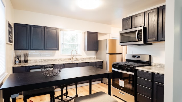 1514 Dean Dr, Albion, MI 49224 - kitchen featuring appliances with stainless steel finishes, a sink, backsplash, and light countertops