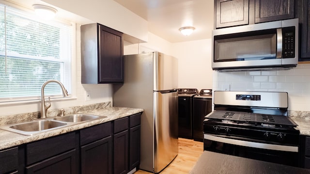 1514 Dean Dr, Albion, MI 49224 - kitchen featuring stainless steel appliances, washer and dryer, a sink, light wood-style floors, and light countertops