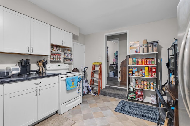 837 Backus St, Jackson, MI 49202 - kitchen with white range with electric stovetop, white cabinetry, and dark countertops