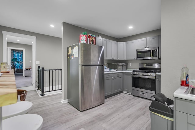 837 Backus St, Jackson, MI 49202 - kitchen with appliances with stainless steel finishes, gray cabinets, light wood finished floors, recessed lighting, and light countertops