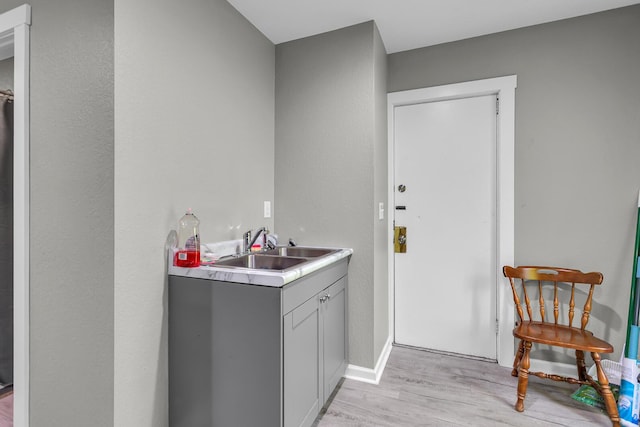 837 Backus St, Jackson, MI 49202 - bar with a sink, light wood finished floors, and baseboards