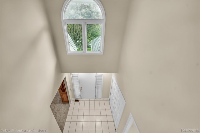 6560 Pleasant Lake Ct Unit 11, West Bloomfield, MI 48322 - stairs featuring tile patterned flooring and a towering ceiling