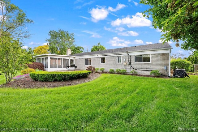 24018 Glen Ridge Ct, Novi, MI 48375 - rear view of property with a sunroom, a yard, and a chimney