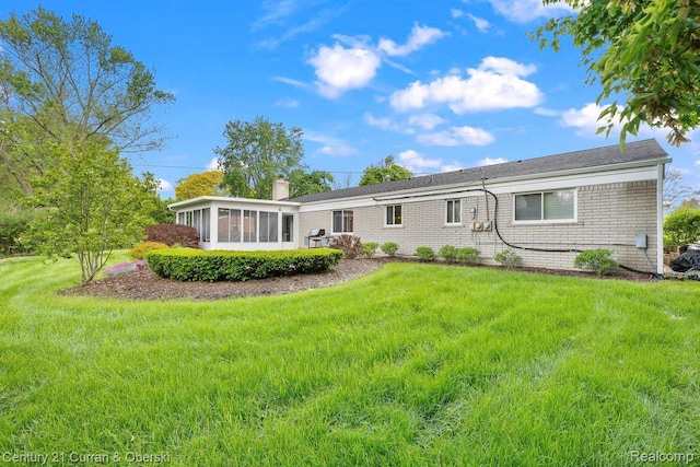 24018 Glen Ridge Ct, Novi, MI 48375 - back of property with a sunroom, a chimney, and a yard