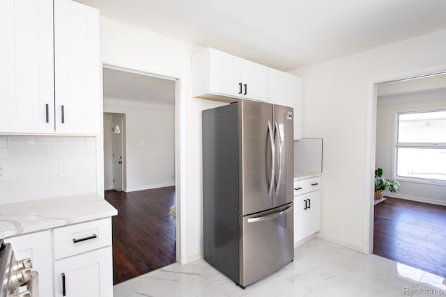 24548 Templar Ave, Southfield, MI 48075 - kitchen with freestanding refrigerator, light stone counters, tasteful backsplash, white cabinetry, and baseboards