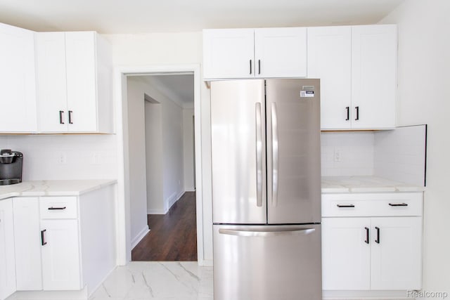 24548 Templar Ave, Southfield, MI 48075 - kitchen featuring freestanding refrigerator, light stone countertops, white cabinetry, and light marble finish flooring
