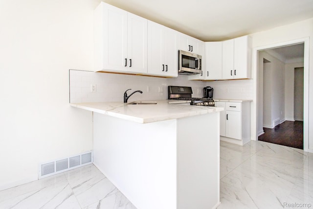 24548 Templar Ave, Southfield, MI 48075 - kitchen with stove, stainless steel microwave, a sink, light stone countertops, and light marble finish flooring