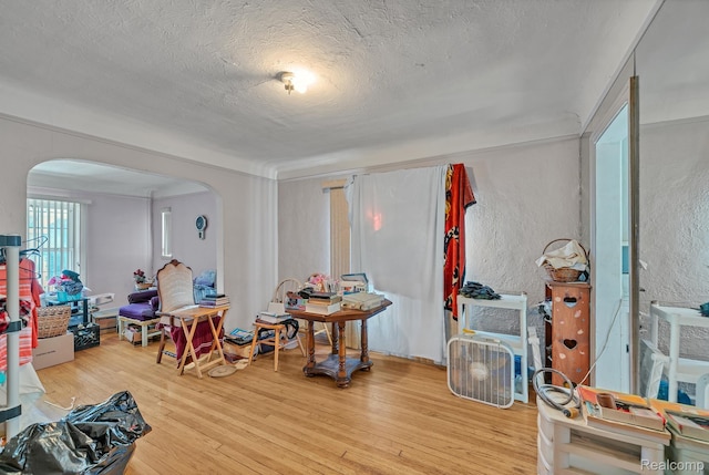 15075 Appoline St, Detroit, MI 48227 - dining area featuring arched walkways, a textured ceiling, wood finished floors, and a textured wall
