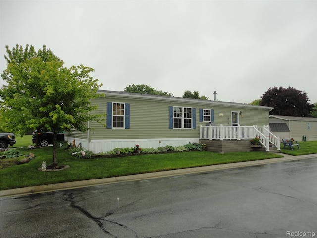 501 Kinloch, Temperance, MI 48182 - manufactured / mobile home featuring a wooden deck and a front lawn