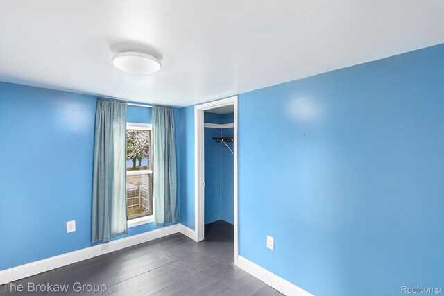 4470 Beach St, Akron, MI 48701 - unfurnished bedroom featuring baseboards, a closet, and dark wood-type flooring