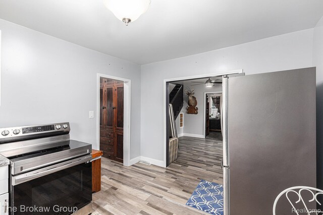 4470 Beach St, Akron, MI 48701 - kitchen with appliances with stainless steel finishes, a ceiling fan, light wood finished floors, baseboards, and white cabinetry