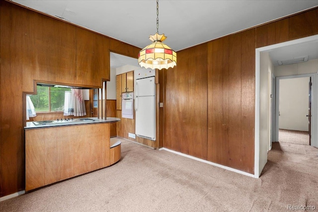 3301 S Kearsley Blvd, Flint, MI 48506 - kitchen with white appliances, wood walls, light carpet, brown cabinets, and decorative light fixtures
