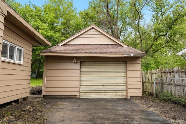 3301 S Kearsley Blvd, Flint, MI 48506 - detached garage with driveway and view of wooded area
