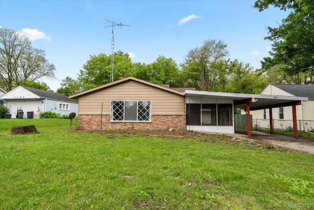 3301 S Kearsley Blvd, Flint, MI 48506 - ranch-style house with brick siding, an attached carport, driveway, and a sunroom