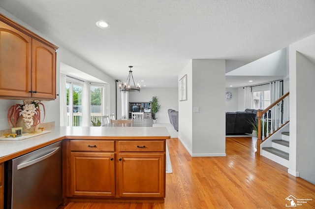 4853 Southpointe Pkwy, Monroe, MI 48161 - kitchen with dishwasher, open floor plan, a chandelier, a peninsula, and light wood finished floors