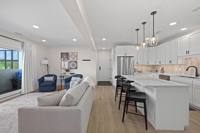 708 Randolph St, Traverse City, MI 49684 - kitchen featuring a sink, stainless steel appliances, a breakfast bar area, a kitchen island, and open floor plan