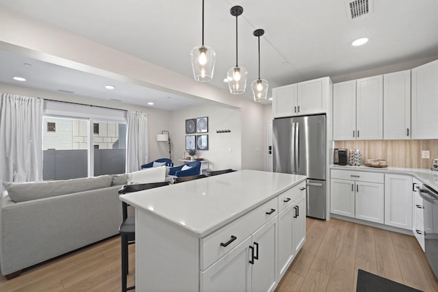 708 Randolph St, Traverse City, MI 49684 - kitchen with appliances with stainless steel finishes, open floor plan, light wood-style floors, white cabinetry, and recessed lighting