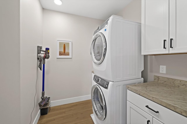 708 Randolph St, Traverse City, MI 49684 - washroom featuring stacked washing machine and dryer, cabinet space, light wood-style flooring, baseboards, and recessed lighting