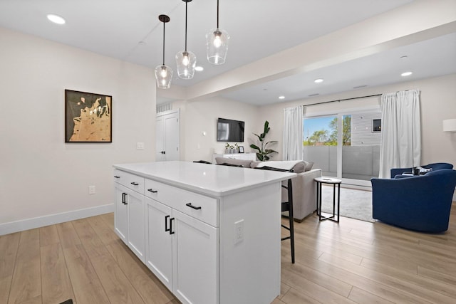 708 Randolph St, Traverse City, MI 49684 - kitchen featuring open floor plan, light wood-style flooring, a kitchen island, white cabinetry, and light countertops