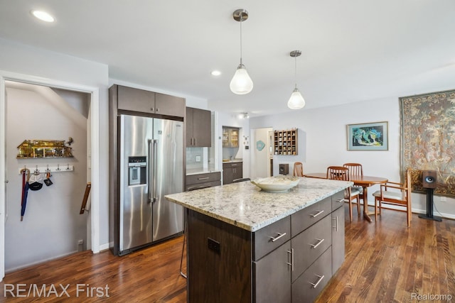2681 Buckingham Ave, Birmingham, MI 48009 - kitchen featuring high end refrigerator, dark wood-type flooring, dark brown cabinetry, decorative light fixtures, and a kitchen island