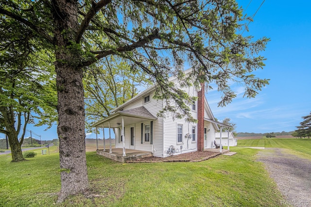 4340 Austin Rd, Saline, MI 48176 - view of side of property with a yard, a porch, a shingled roof, and gravel driveway