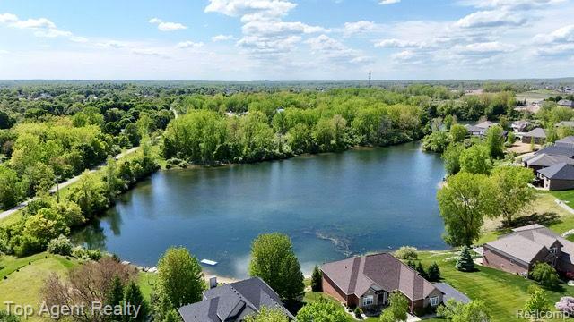109 Willow Lake Dr, Oxford, MI 48371 - aerial perspective of suburban area with a nearby body of water and a heavily wooded area