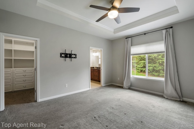 109 Willow Lake Dr, Oxford, MI 48371 - unfurnished bedroom featuring a tray ceiling, carpet flooring, a walk in closet, crown molding, and baseboards