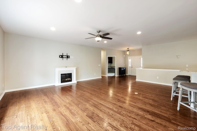 109 Willow Lake Dr, Oxford, MI 48371 - unfurnished living room featuring ceiling fan, a glass covered fireplace, wood finished floors, baseboards, and recessed lighting
