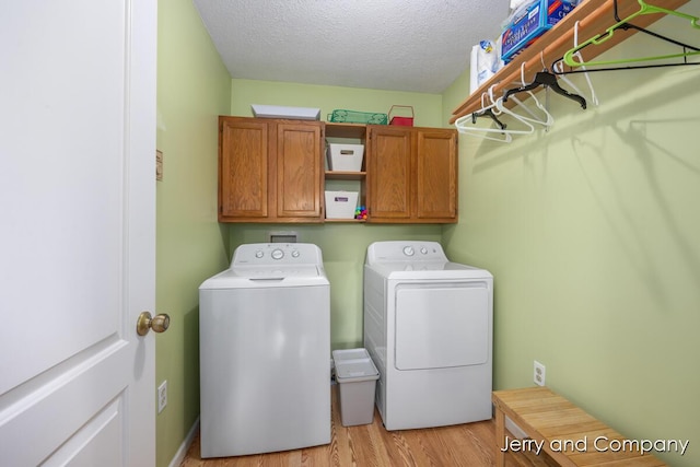 2058 N White Birch Dr, Mears, MI 49436 - laundry area with washer and dryer, cabinet space, light wood finished floors, and a textured ceiling