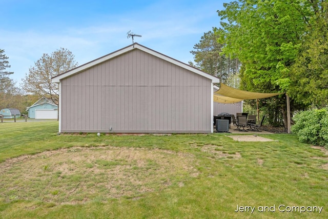 2058 N White Birch Dr, Mears, MI 49436 - view of property exterior with a lawn, a detached garage, and central air condition unit