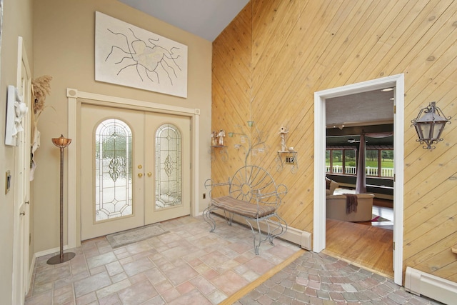 12741 Sharon Hollow Rd, Manchester, MI 48158 - foyer featuring a baseboard radiator, french doors, stone finish flooring, wooden walls, and baseboards
