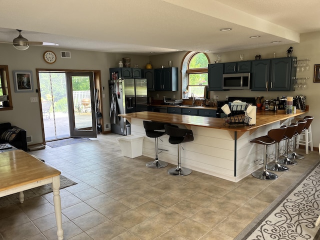 7033 N M-140, Watervliet, MI 49098 - kitchen with appliances with stainless steel finishes, a peninsula, a breakfast bar, a sink, and recessed lighting