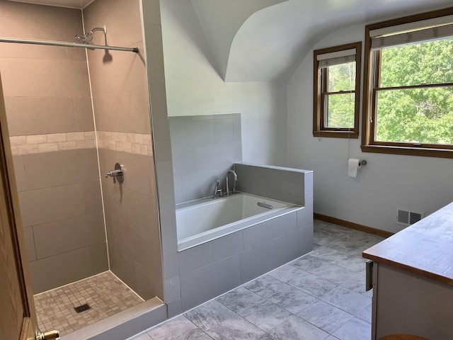 7033 N M-140, Watervliet, MI 49098 - full bathroom with a garden tub, vanity, a tile shower, vaulted ceiling, and tile patterned flooring