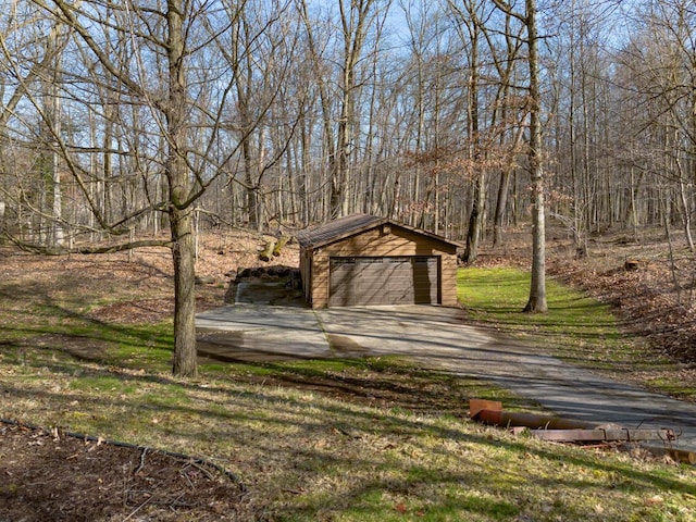 10989 E D E Ave, Richland, MI 49083 - view of yard with an outdoor structure, driveway, a detached garage, and a wooded view