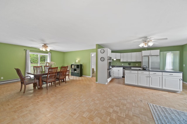 12021 Pope Church Rd, Springport, MI 49284 - kitchen with a ceiling fan, stainless steel appliances, dark countertops, and baseboards
