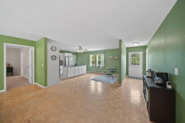 12021 Pope Church Rd, Springport, MI 49284 - living area featuring a baseboard radiator, ceiling fan, and baseboards