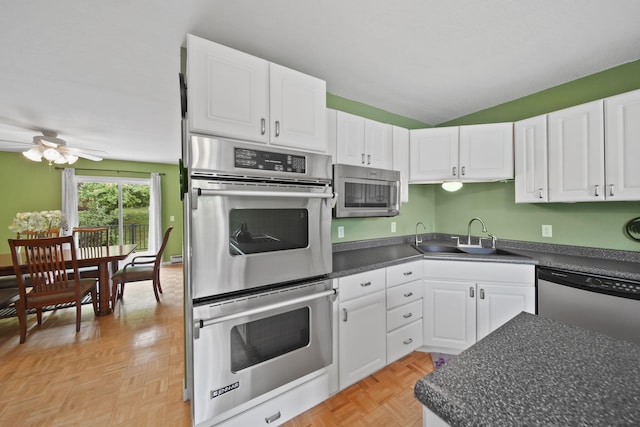 12021 Pope Church Rd, Springport, MI 49284 - kitchen featuring appliances with stainless steel finishes, dark countertops, a sink, white cabinets, and lofted ceiling