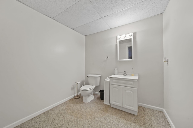 12021 Pope Church Rd, Springport, MI 49284 - half bathroom featuring a drop ceiling, vanity, toilet, and baseboards