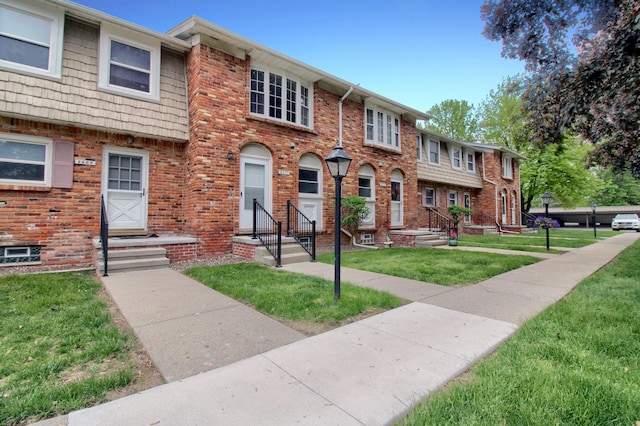 2611 Kingstowne Dr, Michigan, MI 48390 - townhome / multi-family property featuring a front yard, entry steps, and brick siding